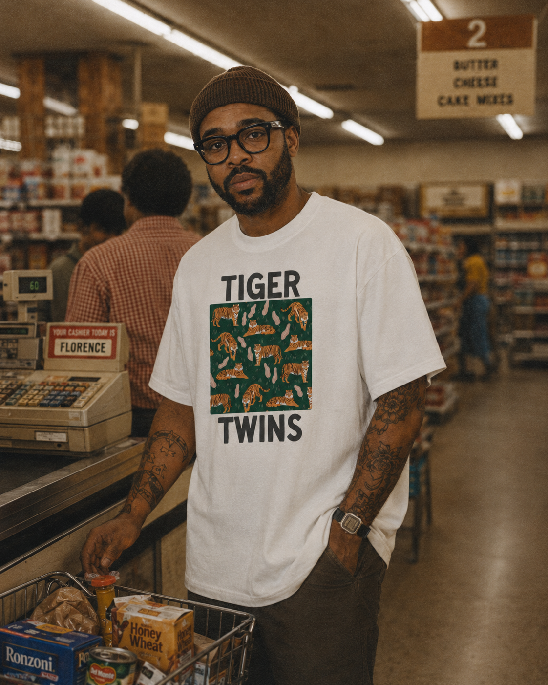Tiger Twins tee in natural — framed tiger pattern print, worn at the checkout.